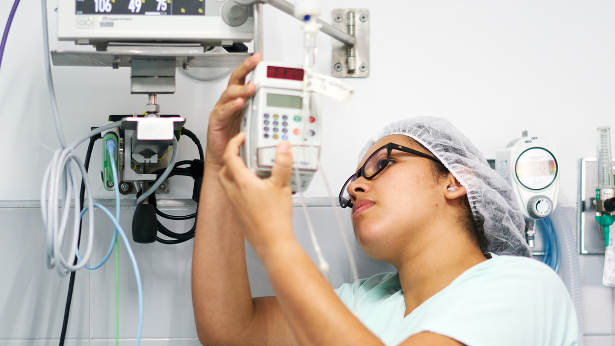 BMETprofessional_261100346 A biomedical engineering technician sets up a medical device in a hospital room.