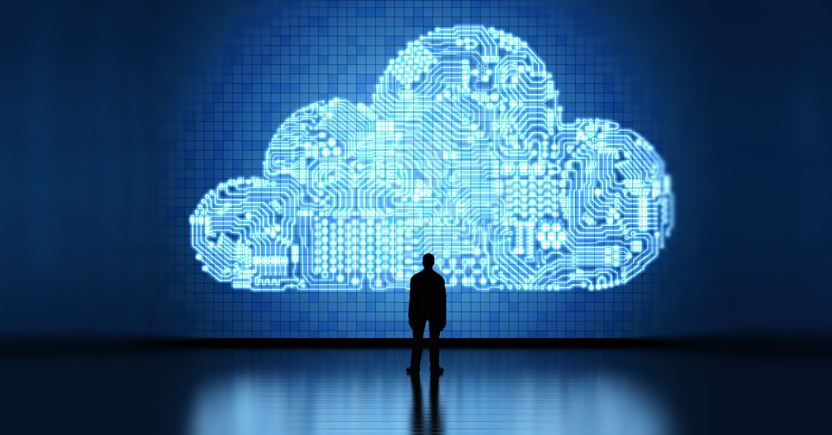Man stands dwarfed by a technological cloud