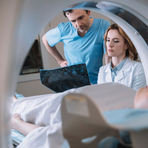 Patient and doctors looking over a CT scan
