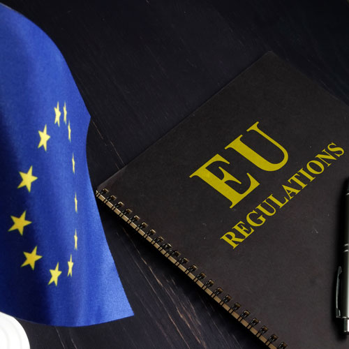 EU flag next to a book of regulations.