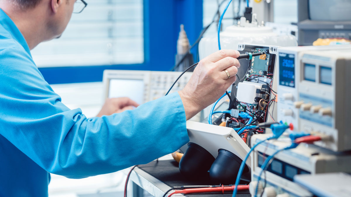 A technician inspects the wiring of a electronic product.