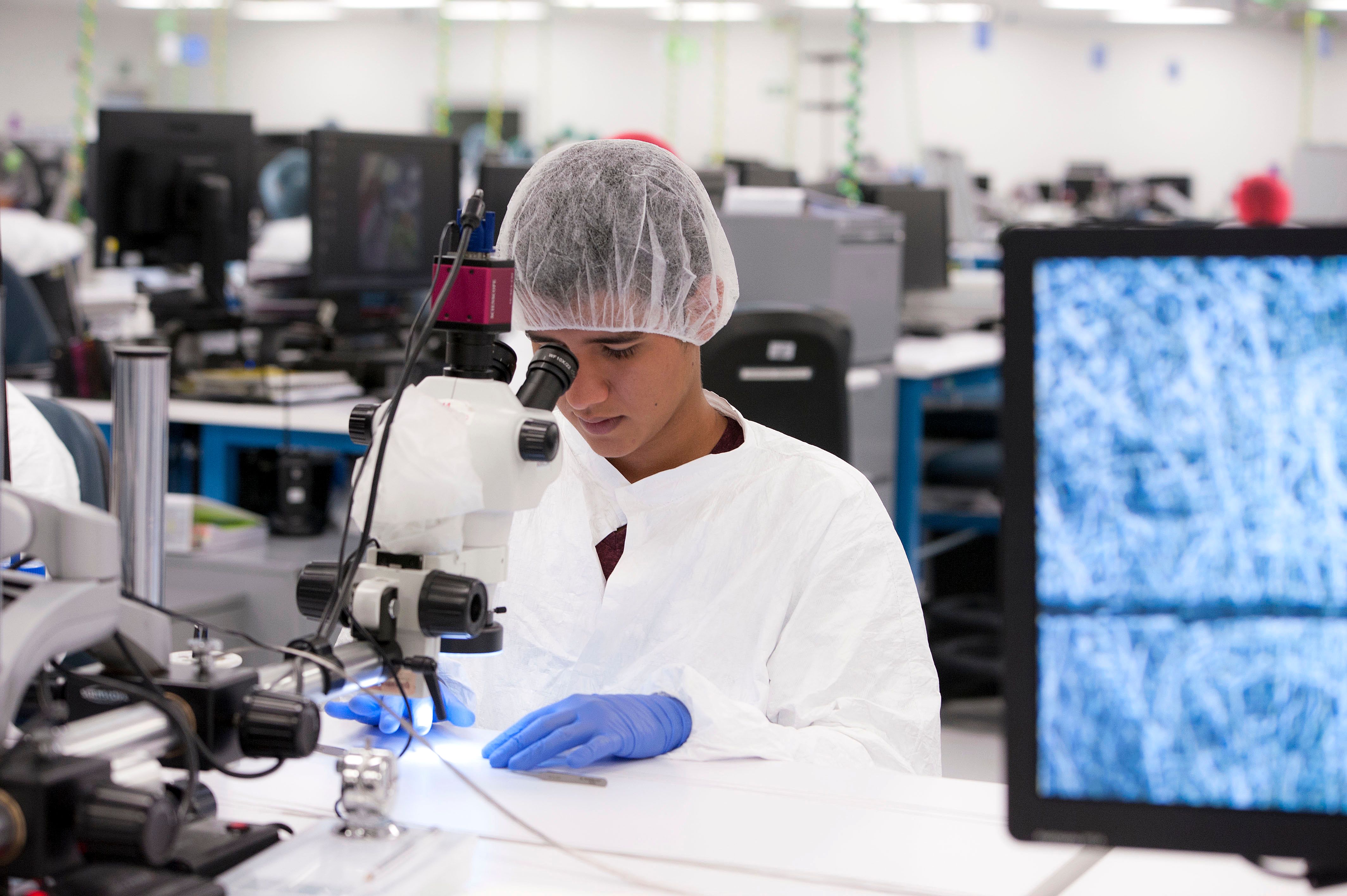 A Costa-Rican employee of Microvention inspecting a device for quality assurance.