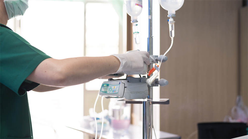 A nurse prepares an IV pump.