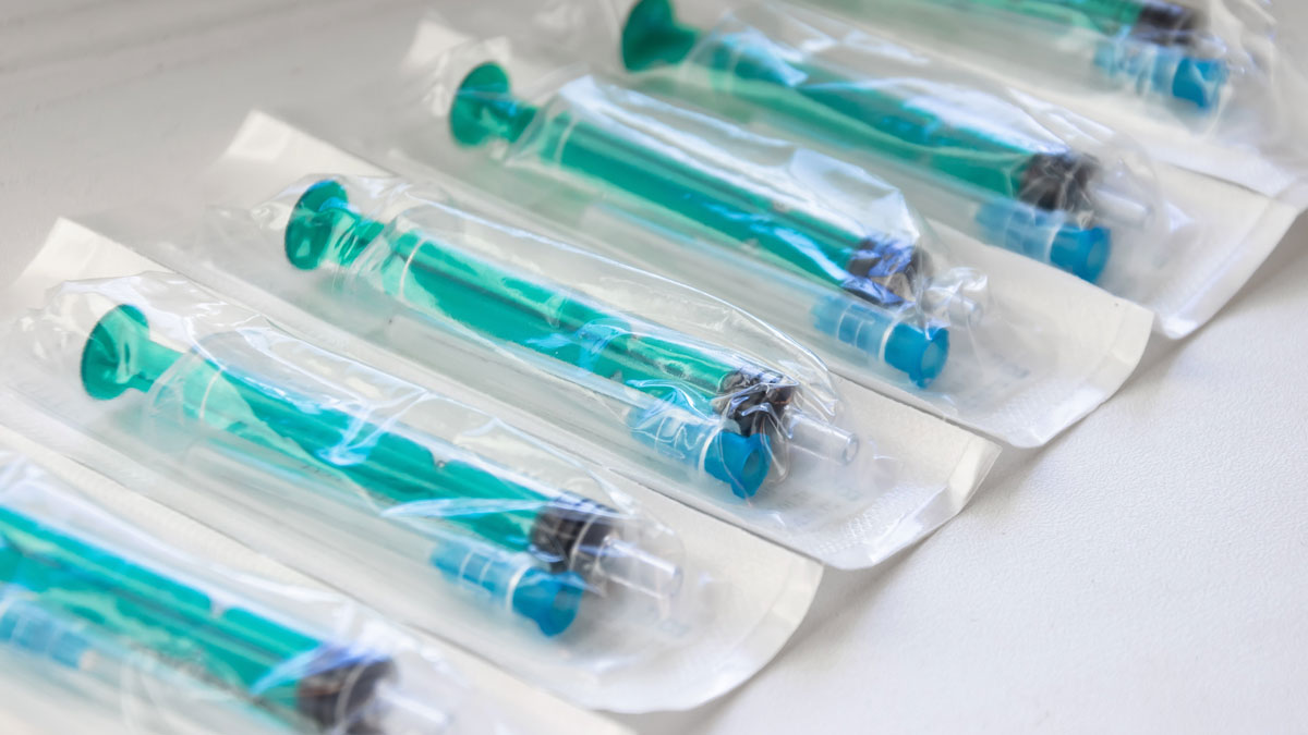 A syringe and needle medical device in its sterile packaging.
